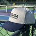 Gray and navy cap with 'USA Pickleball' logo on a pickleball court.